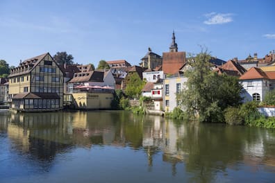 Blick über den Fluss Regnitz auf die Bamberger Altstadt mit Fachwerkhäusern und Kirchturm